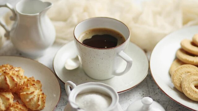 Side view of delicious dessert served. Butter and coconut cookies with cup of black coffee