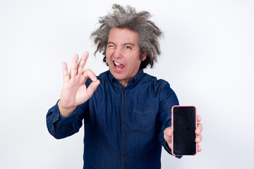 Handsome mature caucasian man with afro grey hair standing over isolated white background holding...