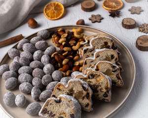 Christmas stollen on plate with nuts in chocolate, nuts and dried fruits. Traditional german sweets. Concept for postcard, holiday greeting. 