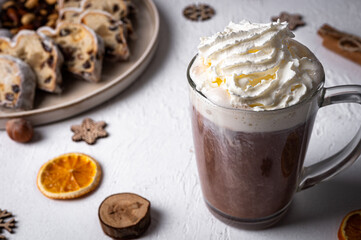 Winter hot drink, cacao with Christmas stollen on wooden board with dried fruits and nuts. Traditional german cake. Concept for postcard, holiday greeting.
