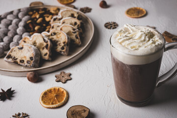 Winter hot drink, cacao with Christmas stollen on wooden board with dried fruits and nuts. Traditional german cake. Concept for postcard, holiday greeting.