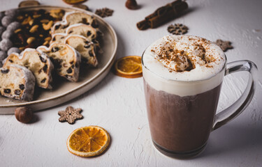 Winter hot drink, cacao with Christmas stollen on wooden board with dried fruits and nuts. Traditional german cake. Concept for postcard, holiday greeting.
