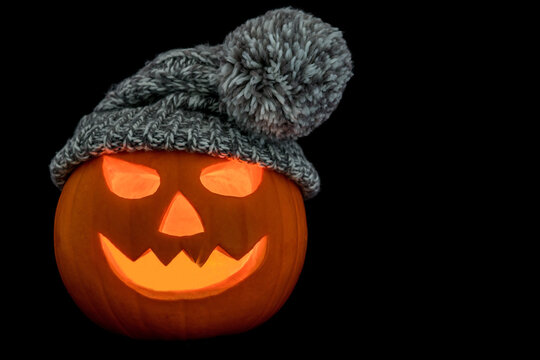 Halloween Pumpkin Wearing a Woolly Hat on a Black Background