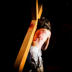 Jesus carrying the Cross into the darkness.Focus on back