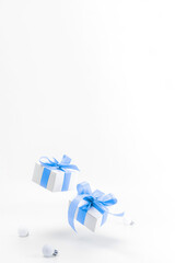 Christmas background blue. White gift box with blue ribbon, New Year balls in xmas composition on white background for greeting card. Decoration and copy space for your text.