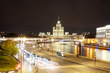 Fototapeta na wymiar Night landscape of the center of Moscow with a view of the high-rise on the Kotelnicheskaya embankment, the Floating bridge of Zaryadye Park and the Moscow river. City in night illumination.