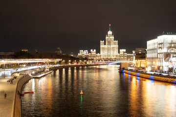 Fototapeta na wymiar Night landscape of the center of Moscow with a view of the high-rise on the Kotelnicheskaya embankment, the Floating bridge of Zaryadye Park and the Moscow river. City in night illumination.