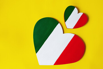 wooden big and small hearts painted in colors of flag of Italy green, white and red on yellow...