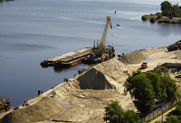 Extraction of sand from the Dnipro River, transshipment from barges to trucks