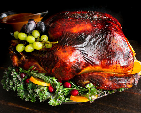 Maple Cider Bourbon Brined Turkey With Bourbon Gravy: A Large Turkey Served On A Platter With Garnishes And Gravy