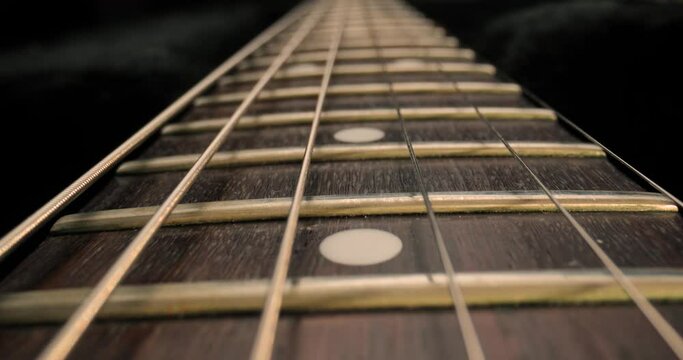 Acoustic guitar fretboard macro closeup slider shot