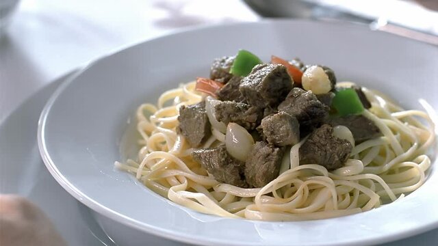 Pasta and beef liver at the dinner table. Close up video.