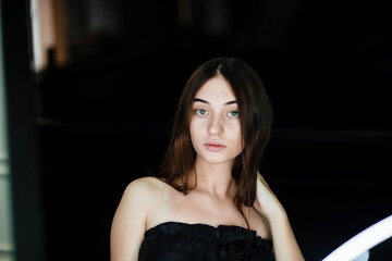 Glamor portrait of beautiful girl model with makeup. The girl is doing makeup and looking in the mirror. Fashion beauty face portrait of beautiful girl. Professional makeup. Fashion style woman.