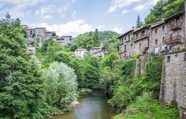 Fototapeta na wymiar Spain, Catalonia. Rupit - a small ancient town of stone in the territory of the Natural Park of the volcanic Garrotxa. Public pool./Rupit (The city of Witch) - a small ancient town of stone.