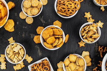 Mixed Snacks on dark background (close up shot; selective focus)