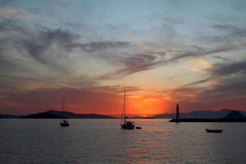 Seascape at sunset. Lighthouse on the coast. Seaside town of Turgutreis and spectacular sunsets	
