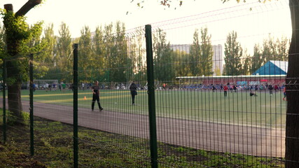 Football field with a running track. People on the playground go in for sports and play football