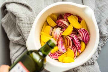 Fresh yellow and Chioggia wedges in a bowl with salt, spices, olive oil

