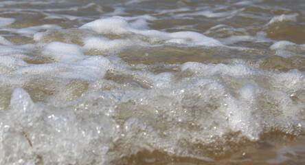 Fototapeta na wymiar Onde sul bagnasciuga al mare in una giornata d'estate