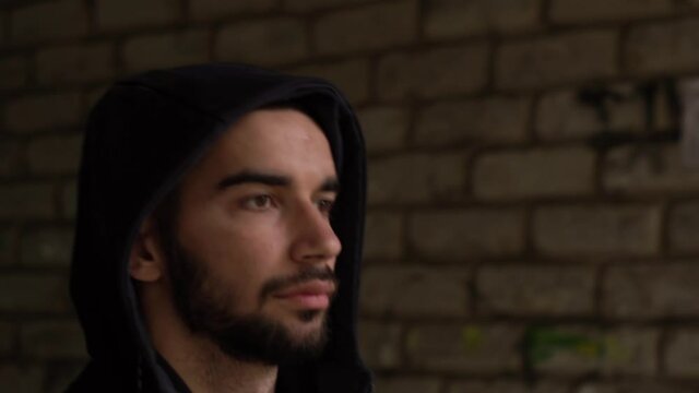 Close-up. athlete goes to training on the gateways, past the gopniks, hooligans, through the opening, passage, arch, corridor, house. Autumn. In black clothes, sports sweatshirt