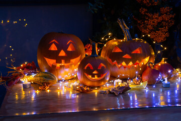 Smiling Halloween Jack-o-Lantern Pumpkins on rustic wooden background.