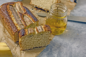 Homemade Vegan Gluten Free Banana Bread Sugar Free. Oatmeal bread with banana, honey and nuts in a baking dish on a gray table surrounded by ingredients. Top view, flat lay. Healthy sweets concept