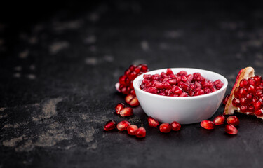 Fresh made preserved Pomegranate seeds on a slate slab (close-up shot; selective focus)