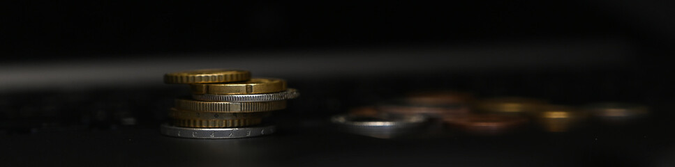 Closeup of three stacks of silver coins on laptop.