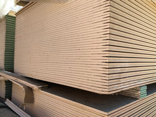 Piled sheets of drywall. Stacked plasterboard sheets. Gypsum cardboard
