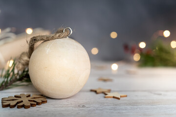 Fototapeta na wymiar christmas still life. Christmas and zero waste, wooden ball and snowflakes a on a wooden table. lights on a dark background. ecological Christmas holiday concept, eco decor