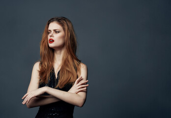 Portrait of a woman in a black dress gesturing with bright makeup emotions with her hands