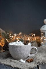 Large coffee mug with marshmallows and spices on the background of objects for gift wrapping