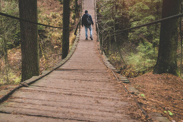 photographer traveler on a suspension bridge in forest wild extreme journey 