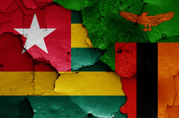 flags of Togo and Zambia painted on cracked wall