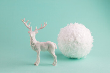 Concept Greeting Card with Big Flying Snowballs and white Deer on a turquoise pastel background.