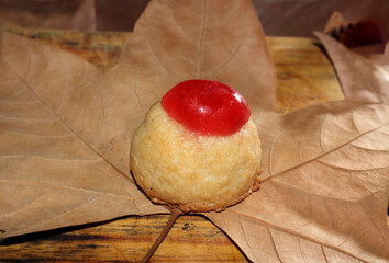 Yolk and candied cherry panellets, on brown background