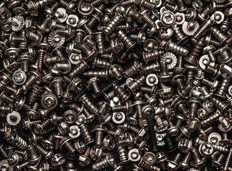 A background of silver screws and bolts. Various screws. Hardware