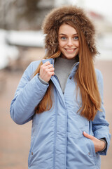 Fototapeta premium young woman are walking in the winter park. Winter park in the snow. Clothing advertising photo concept