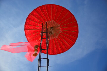 big red umbrella with sky background