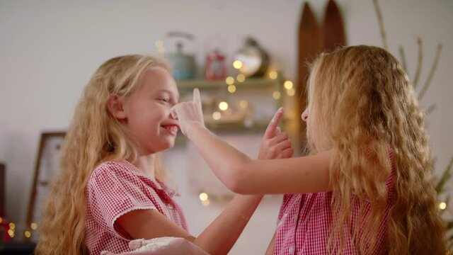 Closeup Of Sweet Girls Twins Having Fun With Flour At Kitchen Daughters Cooking Dough For Cookies Kitchen. Family Spending Time Together At Home Christmas And New Year Concept