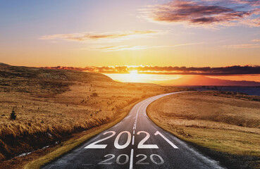 2021 and 2020 on the empty road at sunset. New Year concept