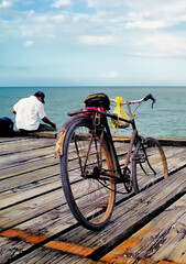 Fototapeta premium A person and his bicycle fishing in the pier of La Ceiba Honduras