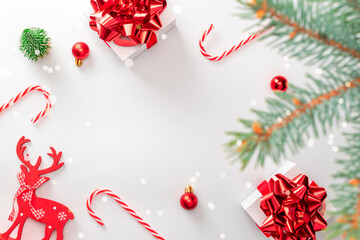 Christmas decoration isolated. White gifts with scarlet bow, red balls, candy and winter tree in xmas decoration on white background for greeting card. Decoration and copy space for your text.