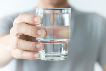 In the Morning, hand of man holding a clear glass of water for drinking.