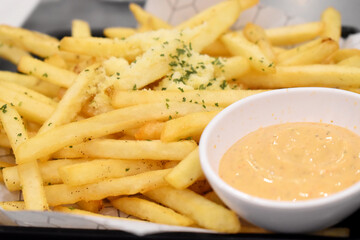 Closeup of Full of fresh french fries on a black plate served with Mayonnaise sauce