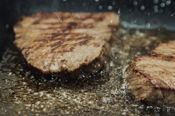 Beef steaks Sizzling in a pan of boiling oil.
