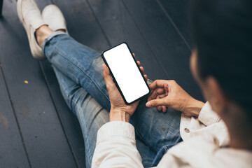 Obraz premium cell phone blank white screen mockup.woman hand holding texting using mobile at coffee shop.background empty space for advertise.work people contact marketing business,technology