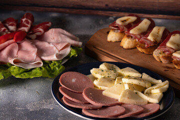 Tables of cold cuts - hams, bondiola -, cheeses and bruschetta tapas, Iberian ham and mozzarella.