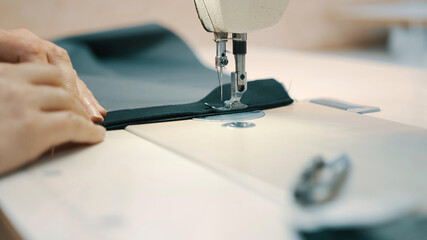 Woman seamstress works at a sewing machine