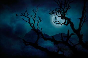 Silhouette of tree branches in forest and blue full moon at midnight with bright and dark clouds,...